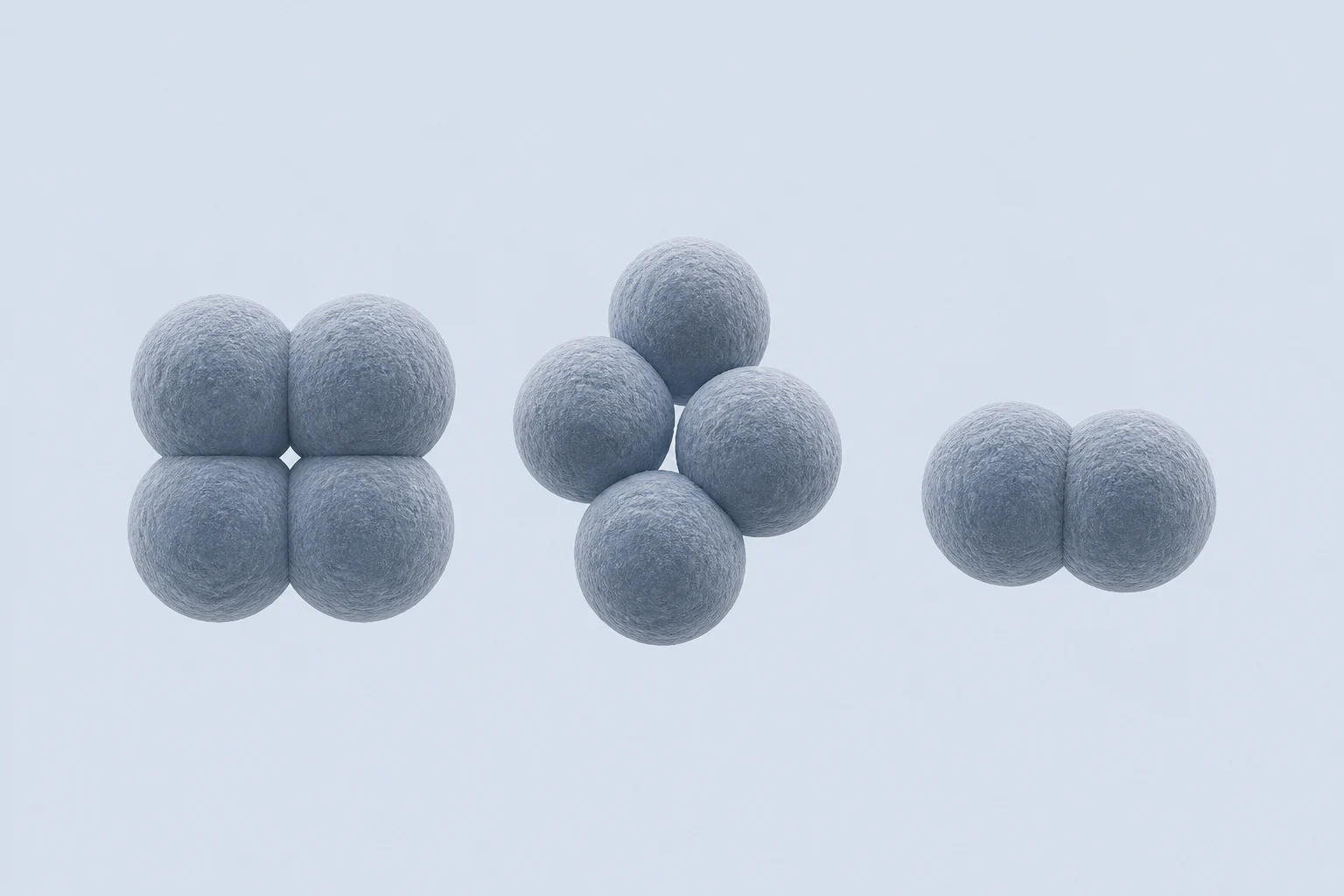 Anaerococcus cocci arranged as a compact tetrad, an irregular four-cell clump, and a pair against a pale cool field.